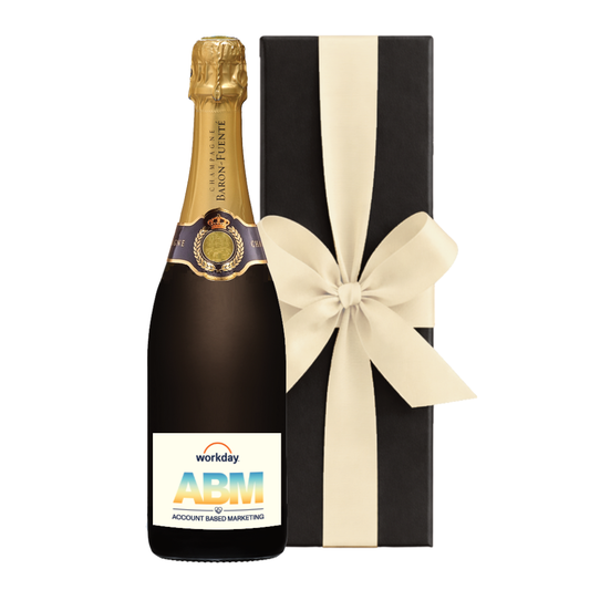 Champagne branded with logo. Grande Réserve bottle with a company logo label beside a black gift box with a cream bow.