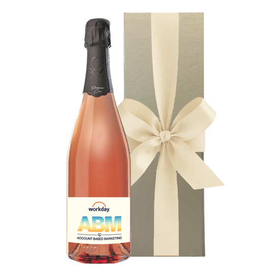 Champagne branded with logo. Premier Cru Rosé bottle with a company logo label beside a gold gift box with a cream bow.