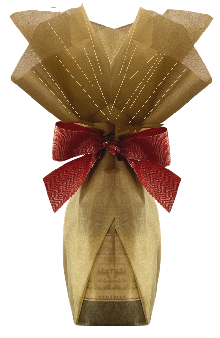 Champagne bottle hand-wrapped in shimmering gold gift wrap, gathered at the neck with a deep red satin bow.