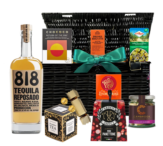 Lidded wicker Christmas hamper with a bottle of 818 Reposado Añejo tequila and festive treats, tied with ribbon