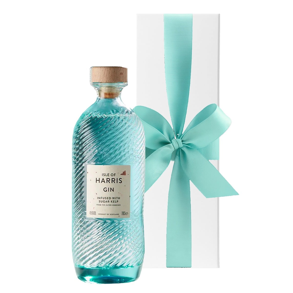 Isle of Harris Gin in its rippled sea-glass bottle beside a white gift box with a large bow