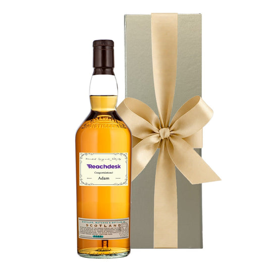 Personalised Speyside single malt whisky with a name and message label beside a luxury gold gift box with a bow